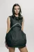 A model wearing a black denim dress with frayed design features.