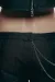 A close-up belt loops, waistband, chain detail and zipper.