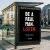 Bus stop advertisement poster with the message “Be a real man. Listen.” displayed in a public urban setting.