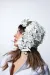 A side profile, close-up of a model wearing a white sequined hat 