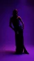 a model wearing a long sparkly dress against a purple background