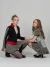Two female models wearing coordinated black, red, and grey fashion pieces posed against a light grey studio backdrop.