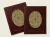 Two burgundy-colored book covers with featuring a circular geometric pysanka (Ukrainian Easter egg) design with radiating lines and decorative patterns. The left cover reads "Strategy and Spec" and the right reads "Between Line and Time," both with saddle-stitch binding visible.