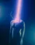 A softly lit portrait of a shirtless figure in blue and purple light with intentional blur and a glowing vertical light element.