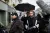 a group of people walking down a street holding an umbrella