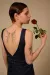 Close up shot of female model looking to side holdings red rose
