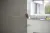 A hand grips the edge of a partially opened kitchen cabinet door in a softly lit interior.