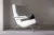 A small black rabbit sits on a modern white armchair in a softly lit room.