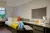 a bedroom with a bed and desk in a room