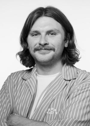 a person wearing a striped shirt and smiling at the camera