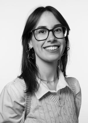 a woman wearing glasses and smiling at the camera