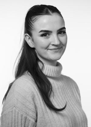 a woman wearing glasses and smiling at the camera