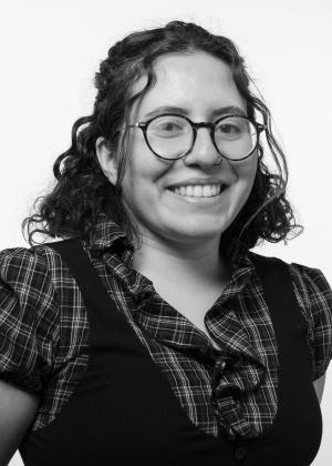 a woman wearing glasses and smiling at the camera
