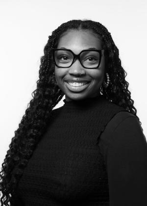 a person wearing glasses and smiling at the camera