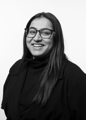 a woman wearing glasses and smiling at the camera