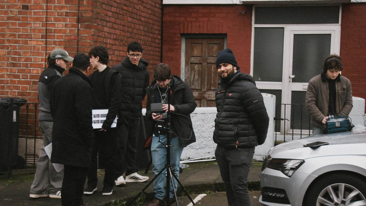 a group of people standing in front of a car