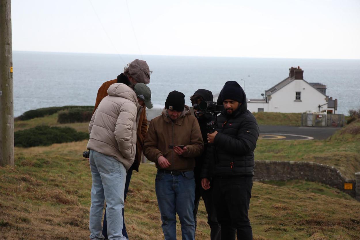 a group of people standing next to a body of water