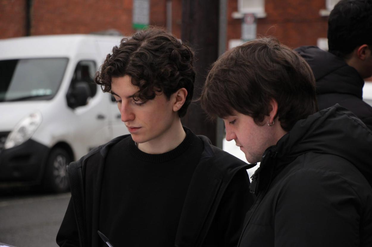 a group of people standing in front of a car