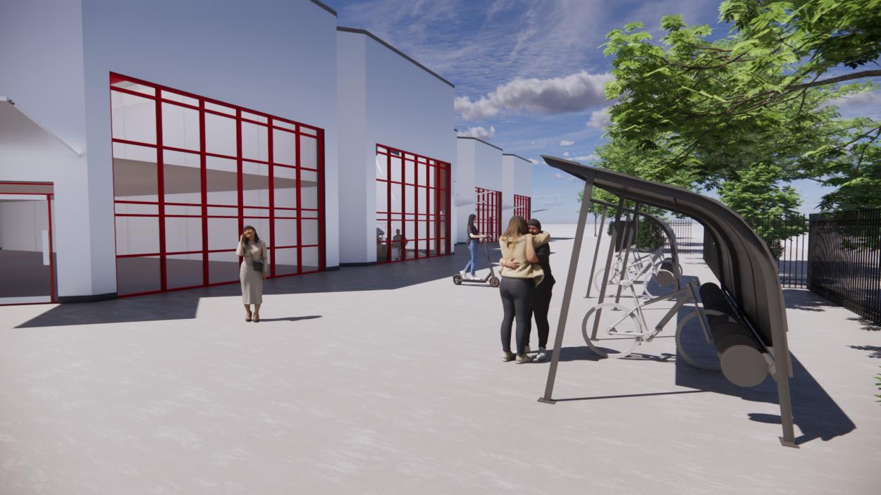 This image shows a 3D architectural visualization of the exterior of The Beacon House, showing a covered bike shelter to encourage sustainable commuting. The render shows the industrial building with large, red-framed windows, people interacting in the exterior, sheltered area for bicycle parking.