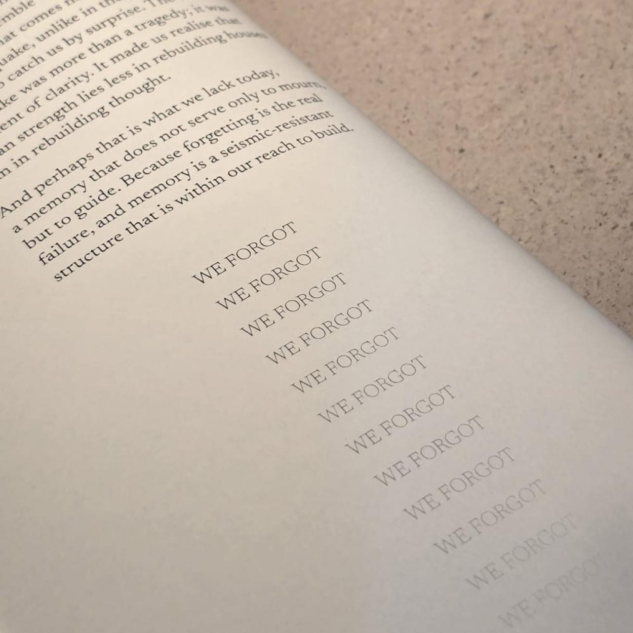 Close-up page from "Fragments: Lisbon, 1755", displaying the repeated phrase “WE FORGOT” in a fading gradient