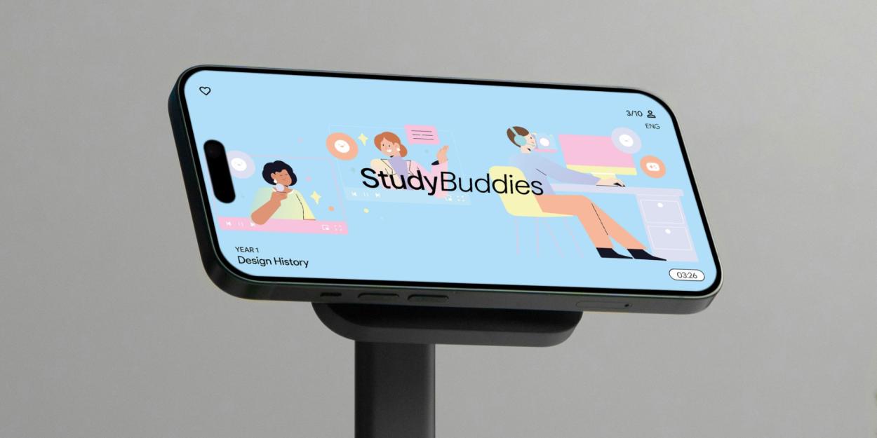 A mobile phone on a stand displaying the colourful, pale blue interface of the "StudyBuddies" app