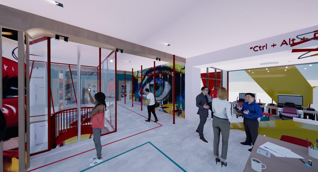 Flexible office and circulation space with open desks, glass partitions, and creative wall  murals, finished with concrete flooring and rubber wayfinding lines.