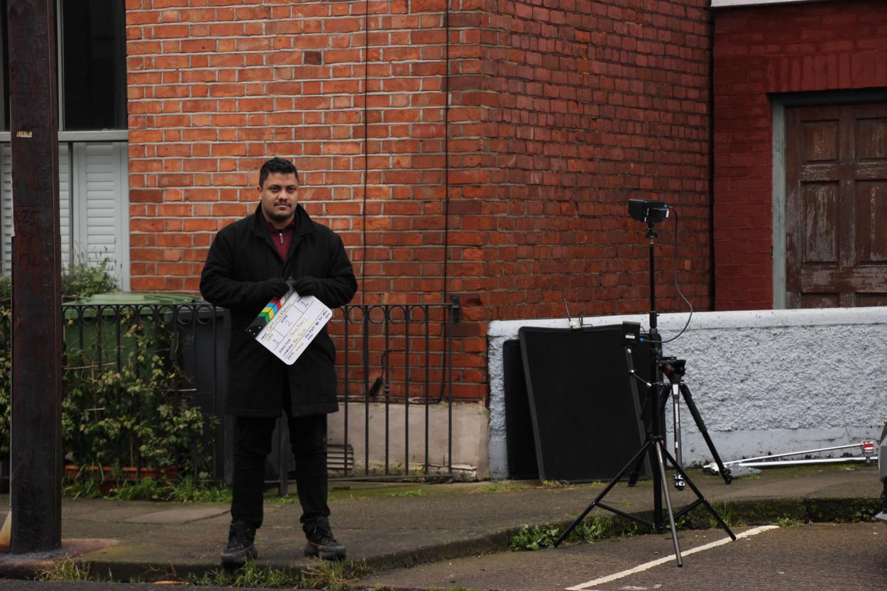 a man standing in front of a brick building