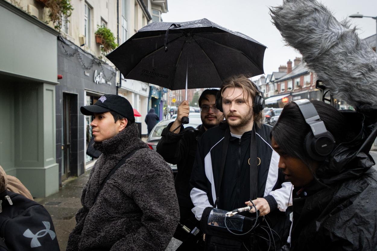 a group of people walking down a street holding an umbrella