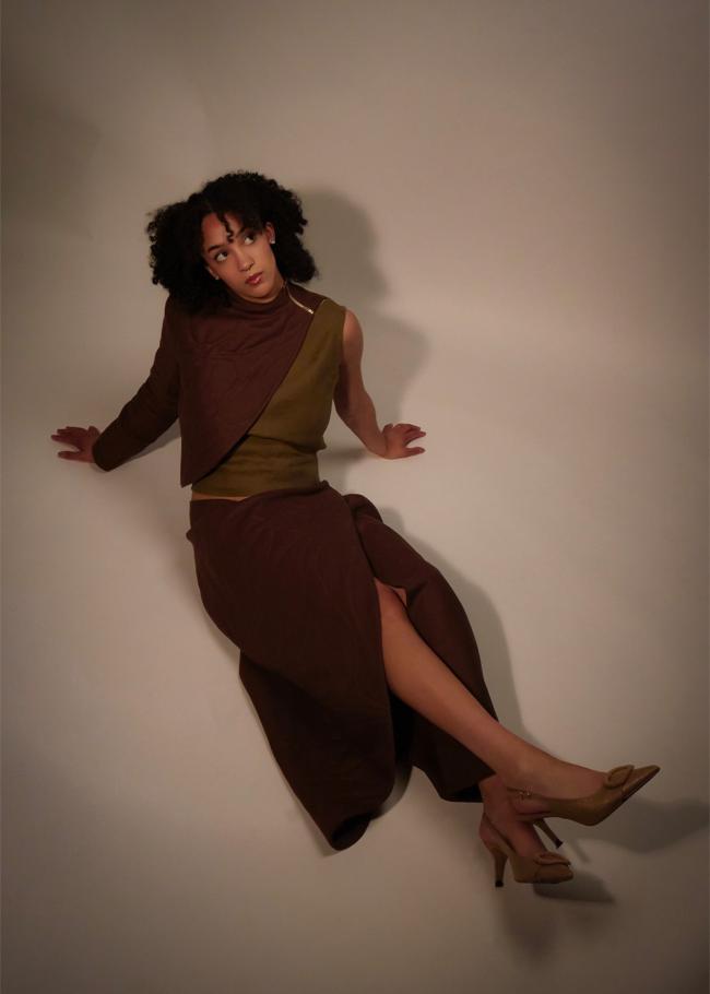 Model wearing matching quilted shawl and wrap skirt, sitting