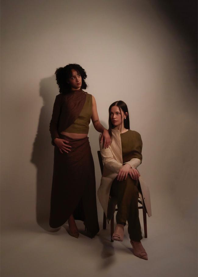 Two models, one sitting and one standing 