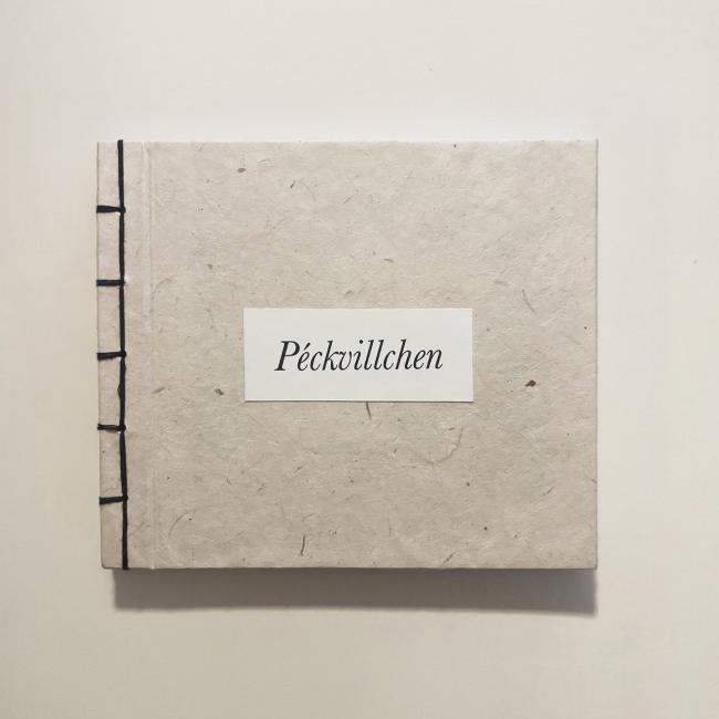 A Japanese-bound book titled “Péckvillchen” showcasing a textured oatmeal paper cover and exposed black spine stitching. 