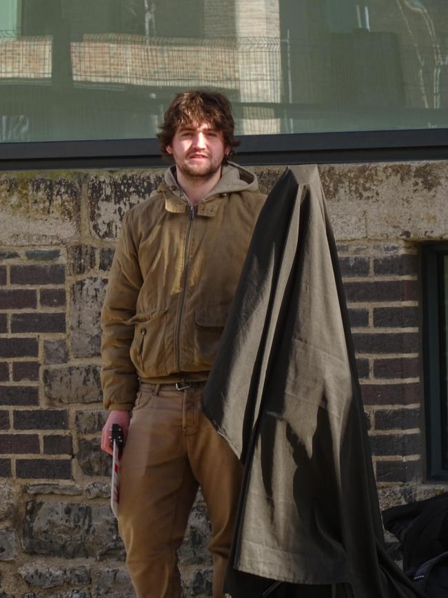 a man standing in front of a brick building