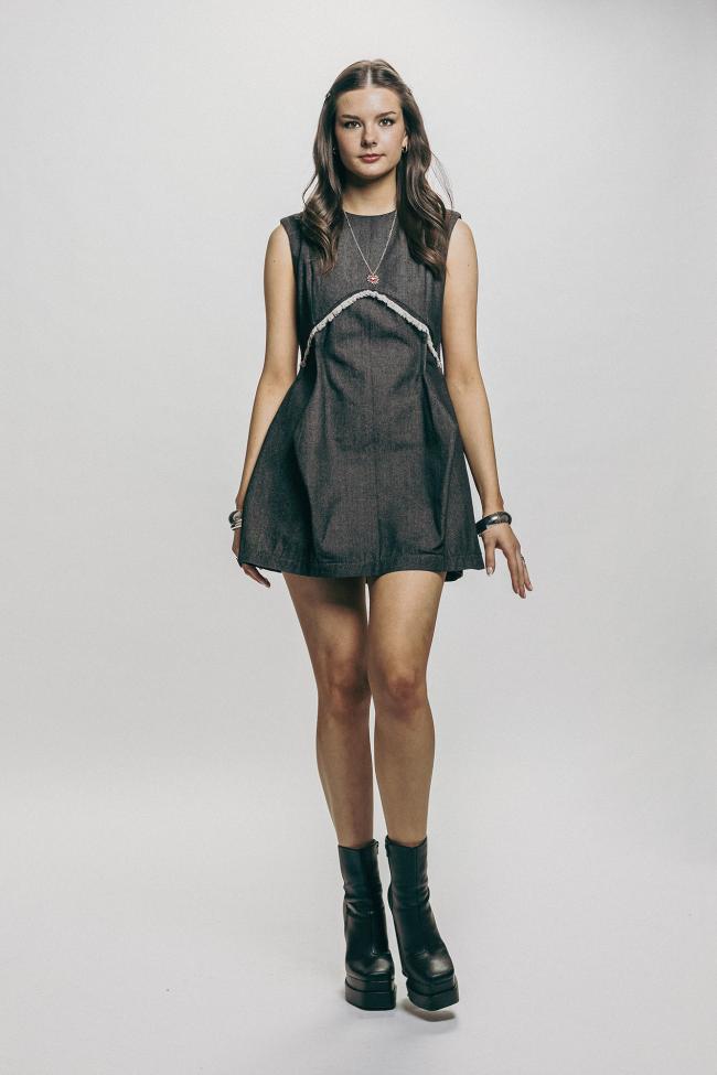 A model wearing a black denim dress.