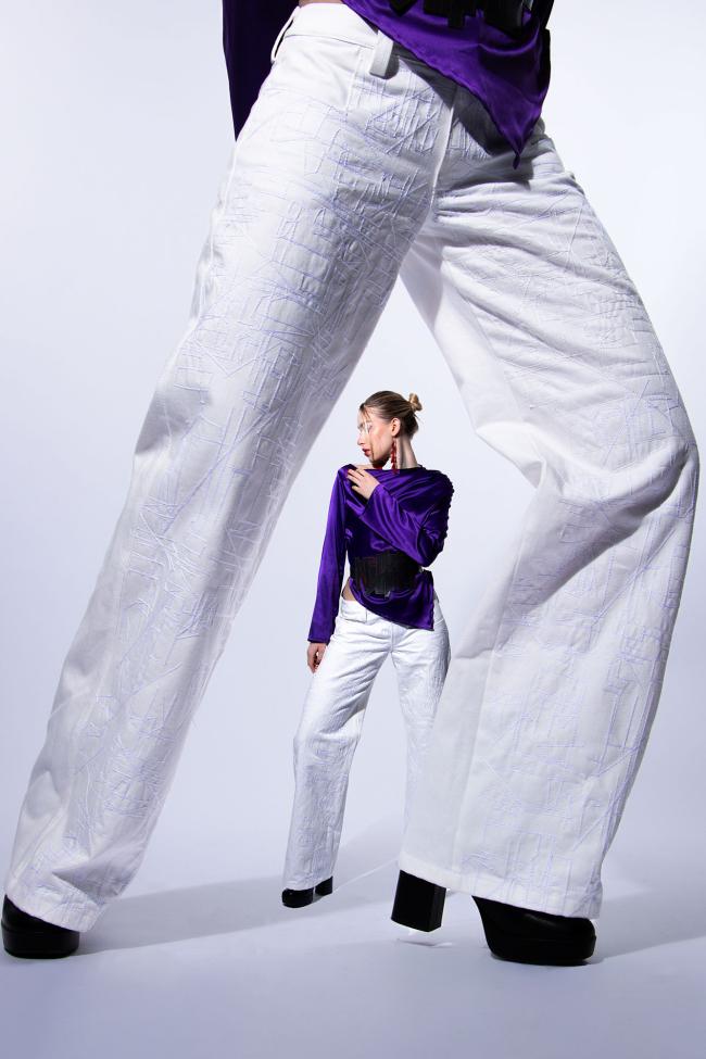 Close-up of embroidered trousers, with the full body image behind