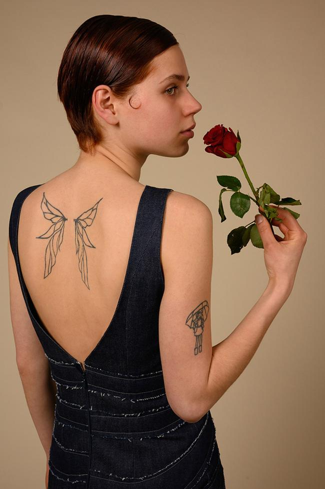 Close up shot of female model looking to side holdings red rose