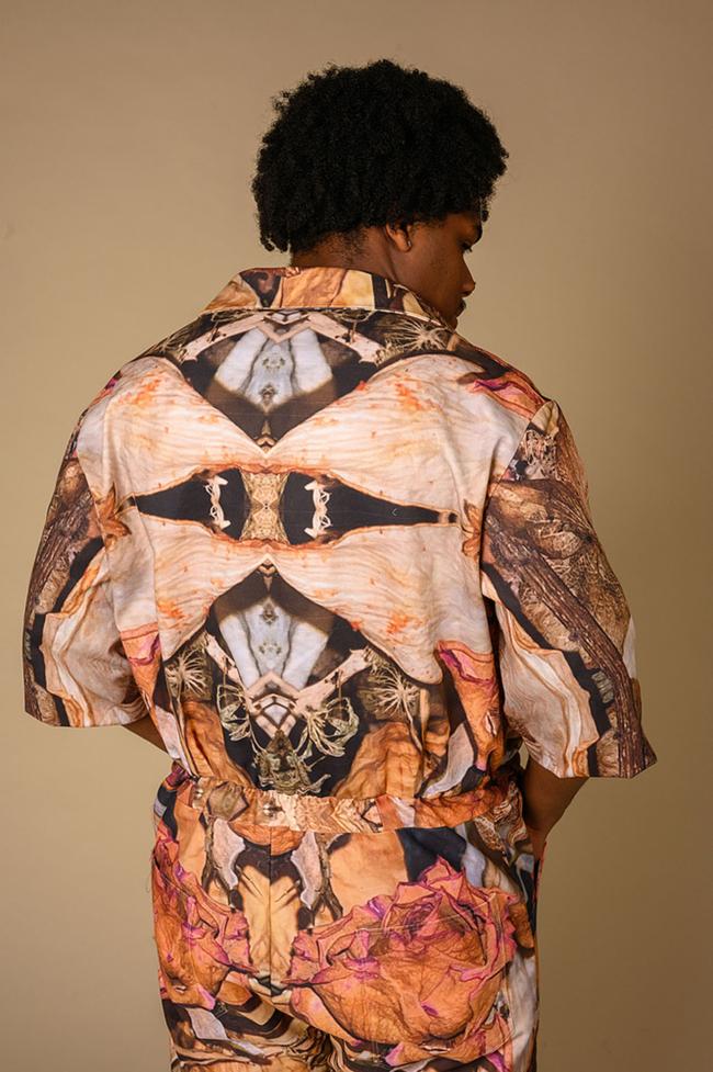Male model wears floral jumpsuit with symmetric print