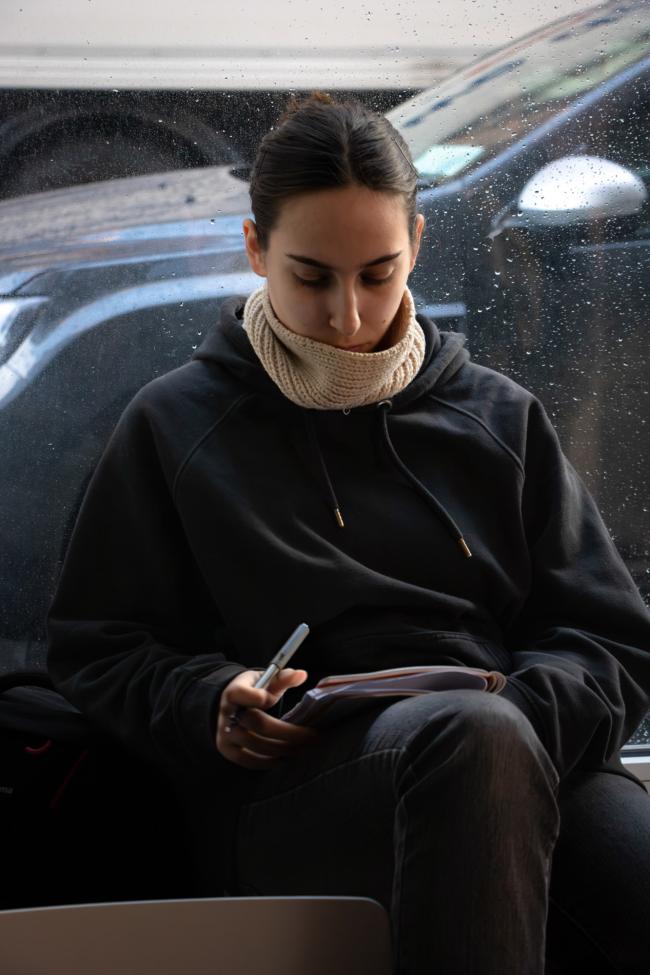 a man using a laptop computer sitting on top of a car