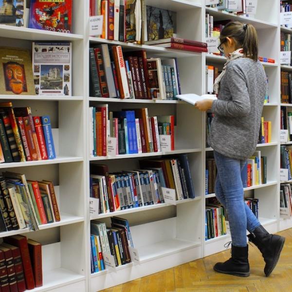 A postgraduate student browsing shelves in a library