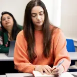 a person sitting at a table using a laptop