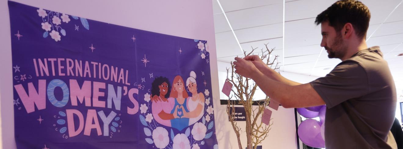 A person adding a note to a positivity tree