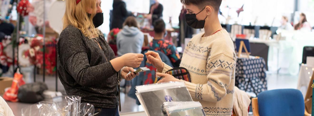 Two people making a purchase at a christmas market
