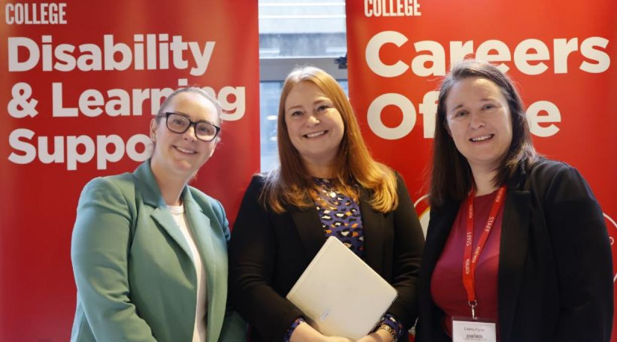 Griffith College staff smiling in front of information stands at Spring Induction 2026