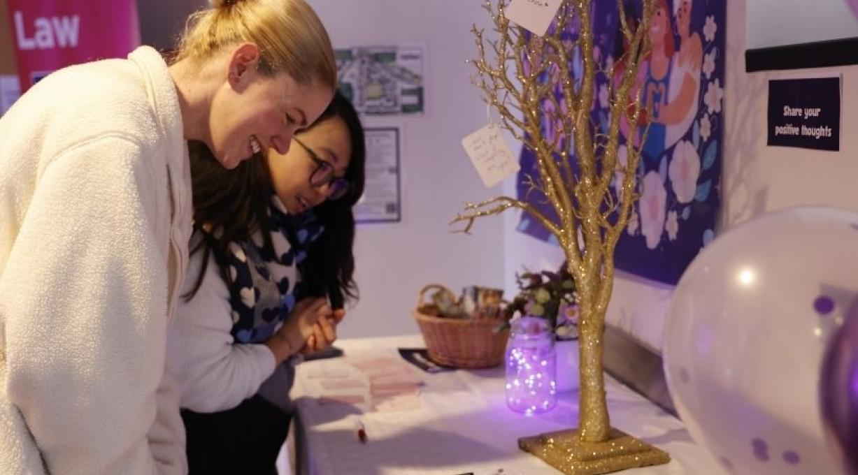 People adding notes to a positivity tree